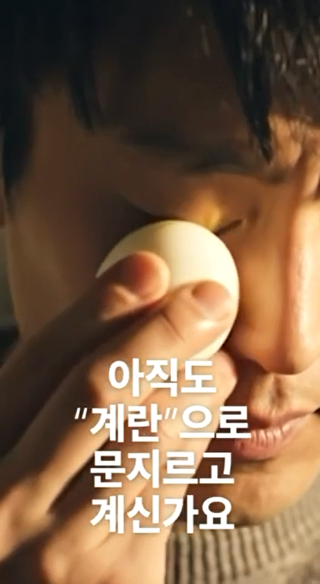 한 남자가 눈을 감고 삶은 계란으로 눈 주위를 문지르고 있다.