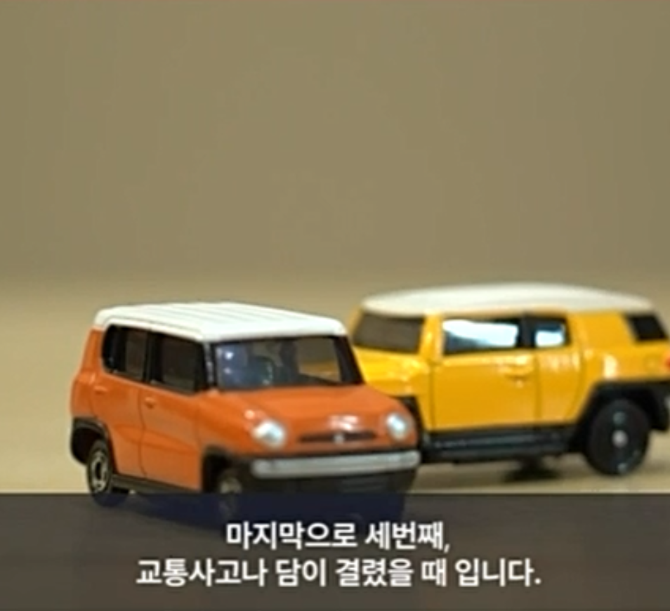 주황색 장난감 자동차와 노란색 장난감 자동차가 부딪힌 모습