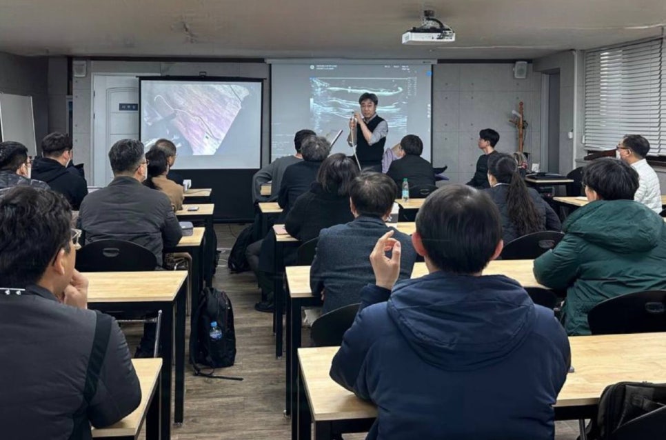 강사가 경혈 초음파 실습 세미나에서 참석자들에게 강의하고 있는 모습