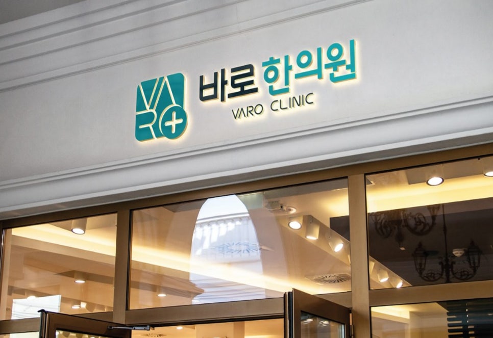 바로 한의원 간판이 건물 입구 위에 밝게 빛나고 있는 모습.