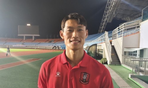 붉은 유니폼을 입은 남자 축구 선수가 밤에 경기장에서 미소 짓고 있다 — 서울 바로한의원 초음파 약침·도침