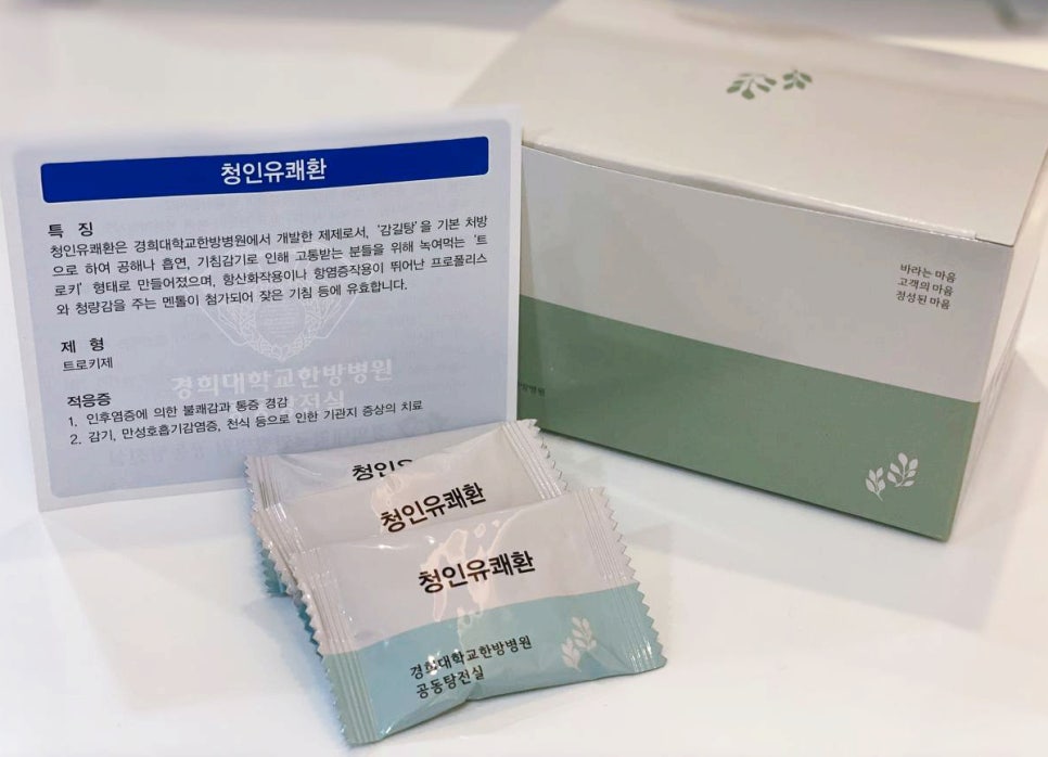 청인유쾌환 한방 트로키 제품의 상자, 설명서, 그리고 개별 포장된 트로키 여러 개가 놓여 있습니다.