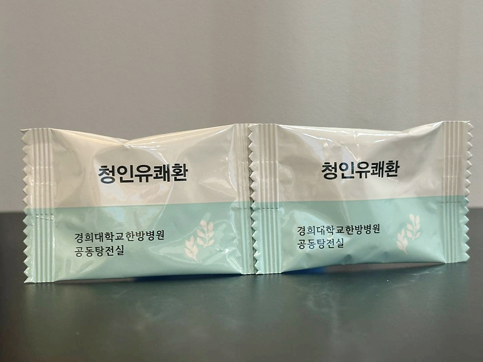 흰색과 연두색 포장지에 '청인유쾌환'과 '경희대학교한방병원 공동탕전실' 문구가 있는 두 개의 제품 사진.