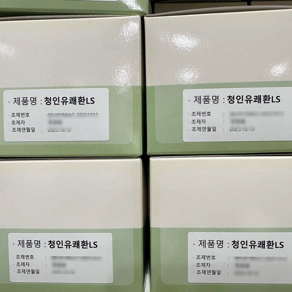 연한 녹색과 흰색 상자들이 쌓여 있고, 각 상자에는 '제품명 : 청인유쾌환LS' 라벨과 조제 정보가 인쇄되어 있다.