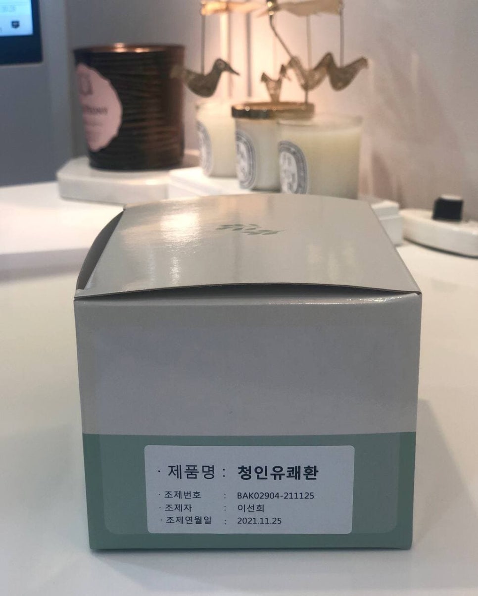 청인유쾌환이라고 적힌 연회색 상자가 흰색 탁자 위에 놓여 있다.