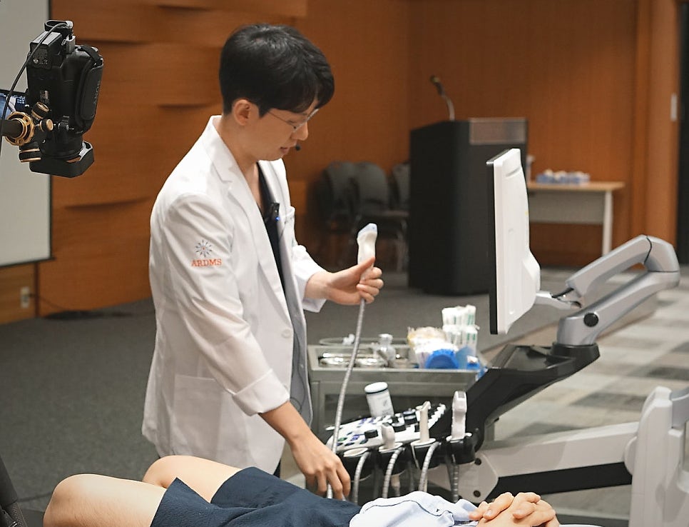 한의사가 누워있는 환자의 발목에 초음파 검사를 하는 모습