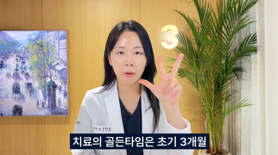 흰색 가운을 입은 여성이 손가락 세 개를 펴고 있으며, 숫자 3이 화면에 표시되어 있다.