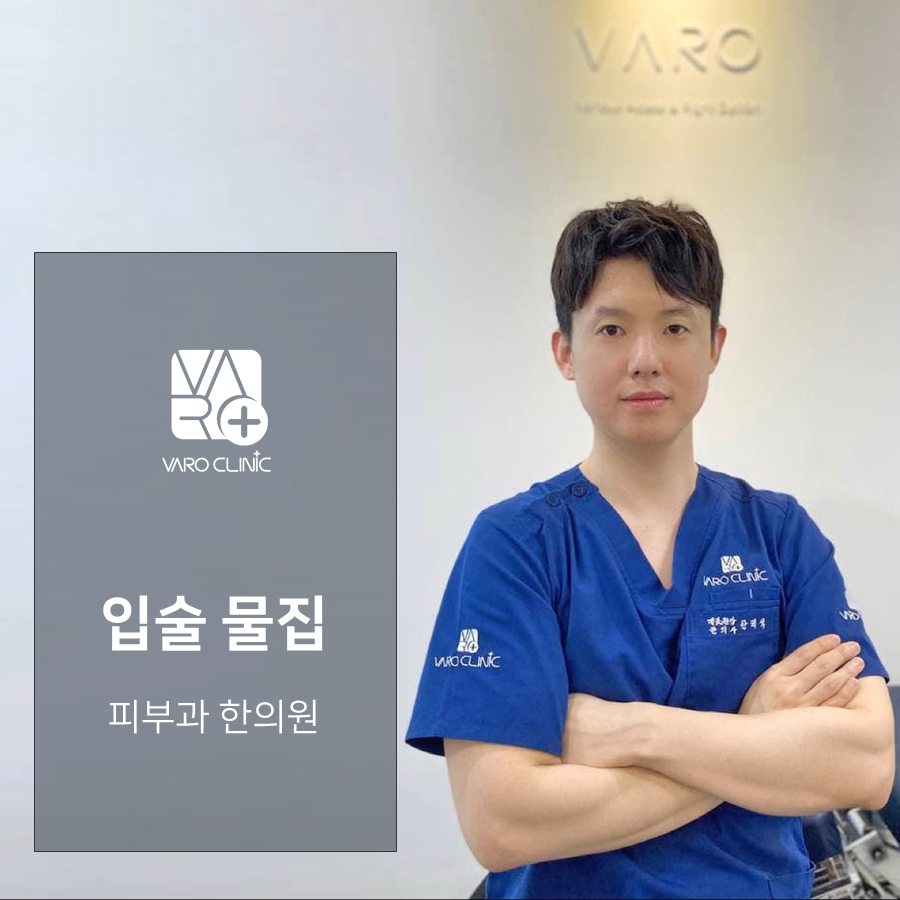 파란색 스크럽을 입은 남자 의사가 팔짱을 끼고 서 있고, 옆에는 '입술 물집', '피부과 한의원' 문구와 VARO CLINIC 로고가 있는 회색 패널이 있다 — 서울 바로한의원 초음파 약침·도침