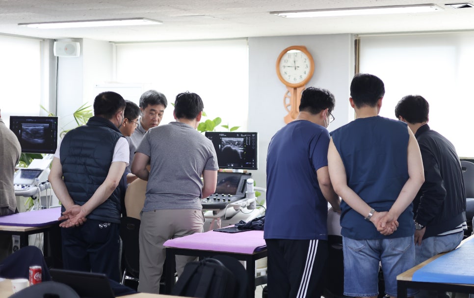 여러 명이 초음파 기기 화면을 보며 실습하는 모습