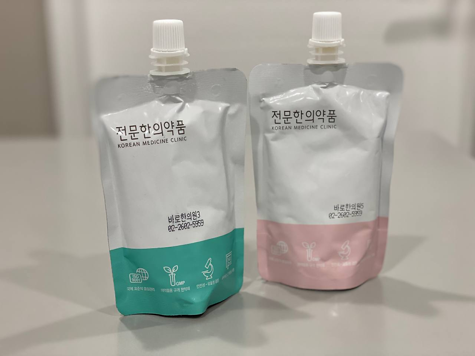 두 개의 한약 파우치 사진. 왼쪽은 아래가 청록색, 오른쪽은 분홍색이다.