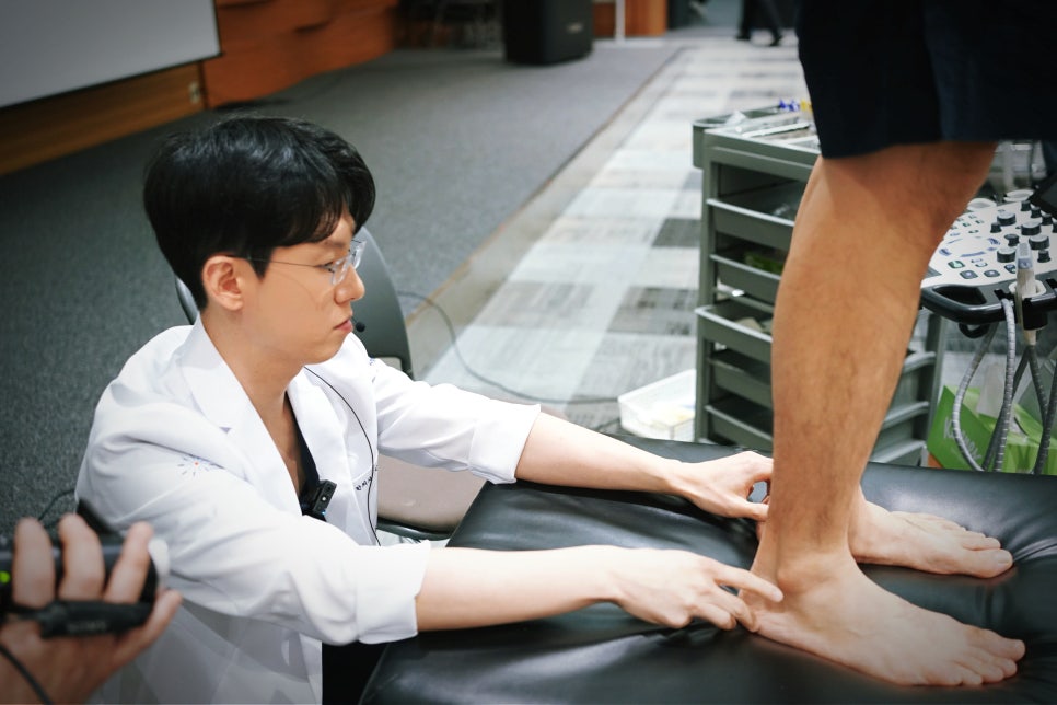 의료진이 환자의 발과 발목을 초음파 기기로 검사하고 있다.
