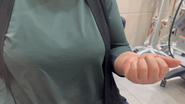 초록색 상의를 입은 사람의 오른손이 손바닥을 위로 향한 채 손가락을 구부리고 있다.