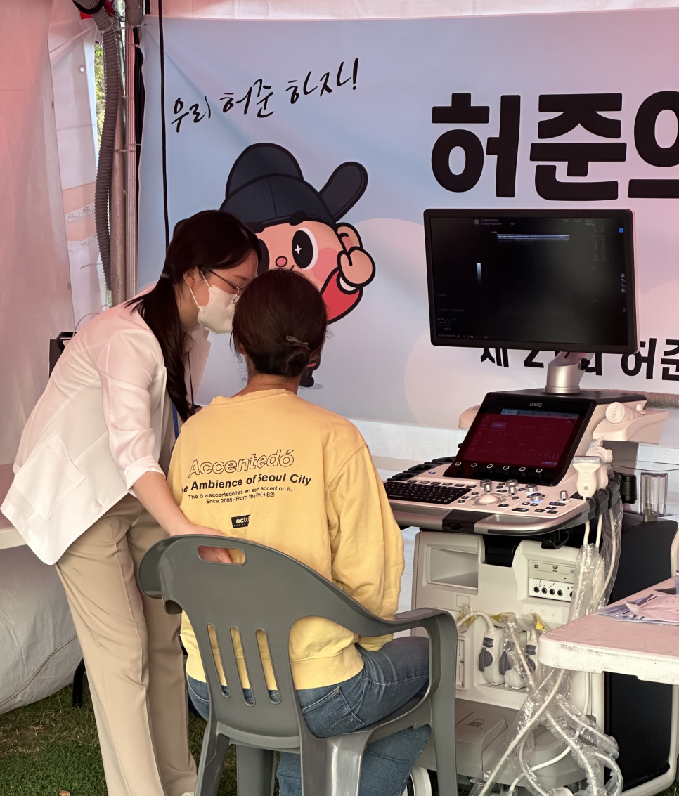 한의원 부스에서 한의사가 환자에게 경혈 초음파 검사를 진행하고 있다.