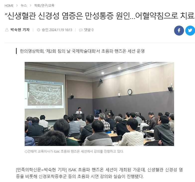 강사가 초음파 이미지가 보이는 화면 앞에서 청중에게 강의하고 있다.