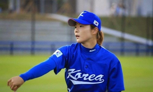 파란색 야구 유니폼과 모자를 착용한 여성이 야구장에서 옆을 바라보고 있는 모습 — 서울 바로한의원 초음파 약침·도침