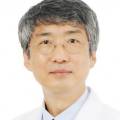 안경을 쓴 중년 남성이 흰색 의사 가운을 입고 정면을 바라보고 있는 모습 — 서울 바로한의원 초음파 약침·도침