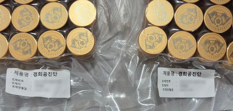 금색의 둥근 한약 환들이 투명한 비닐에 포장되어 트레이에 담겨 있으며, '제품명: 경희공진단' 라벨이 붙어 있다.