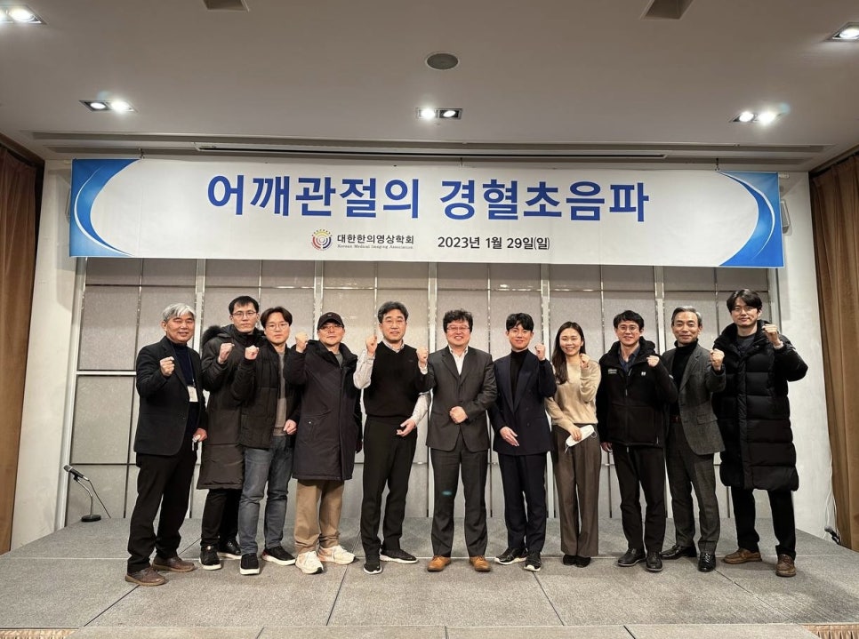 대한한의영상학회 어깨 경혈초음파 보수교육에 참석한 사람들이 현수막 앞에서 주먹을 쥐고 서 있는 모습.