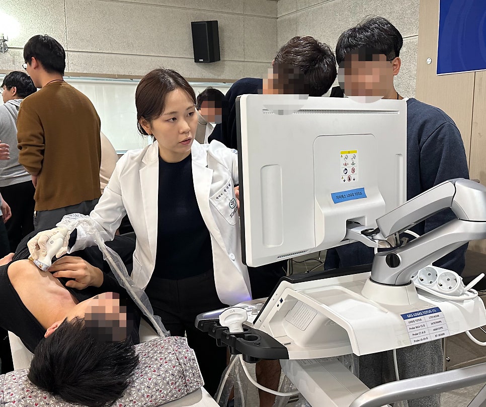 한의사가 환자의 목에 초음파 기기를 대고 모니터를 보며 시술하는 모습