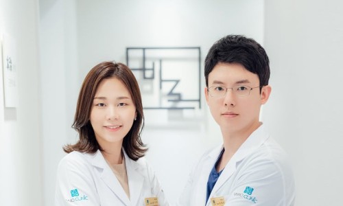 한의원 복도에서 흰 가운을 입은 남녀 의료진 두 명이 서 있다.