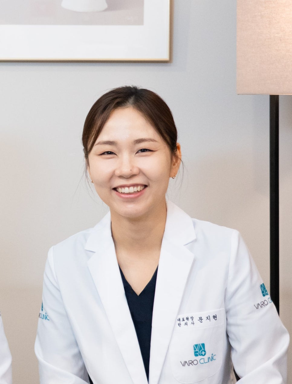 흰색 가운을 입고 미소 짓는 여성 한의사