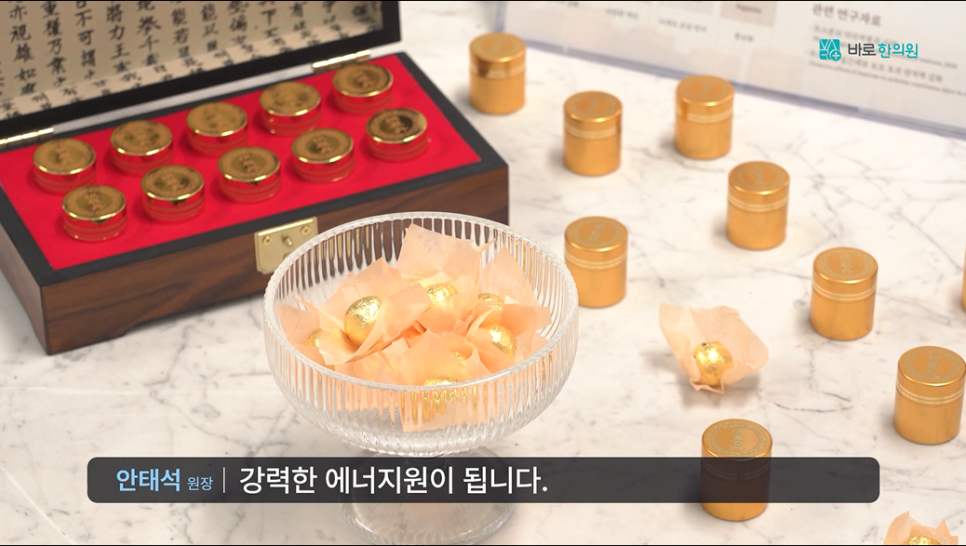 붉은색 안감의 나무 상자에 담긴 금색 용기들과 대리석 위에 놓인 금색 용기들, 그리고 유리 그릇에 담긴 금색 포장 환약들