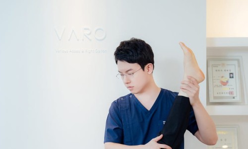 한의원에서 한의사가 환자의 다리를 잡고 있는 모습