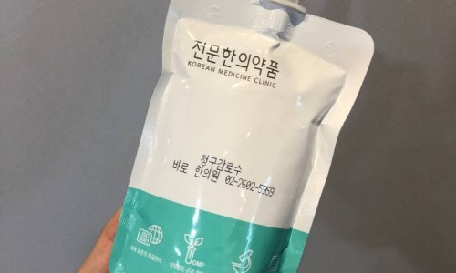 한의원 로고와 '청구감로수' 제품명이 인쇄된 한약 파우치를 손으로 들고 있는 모습