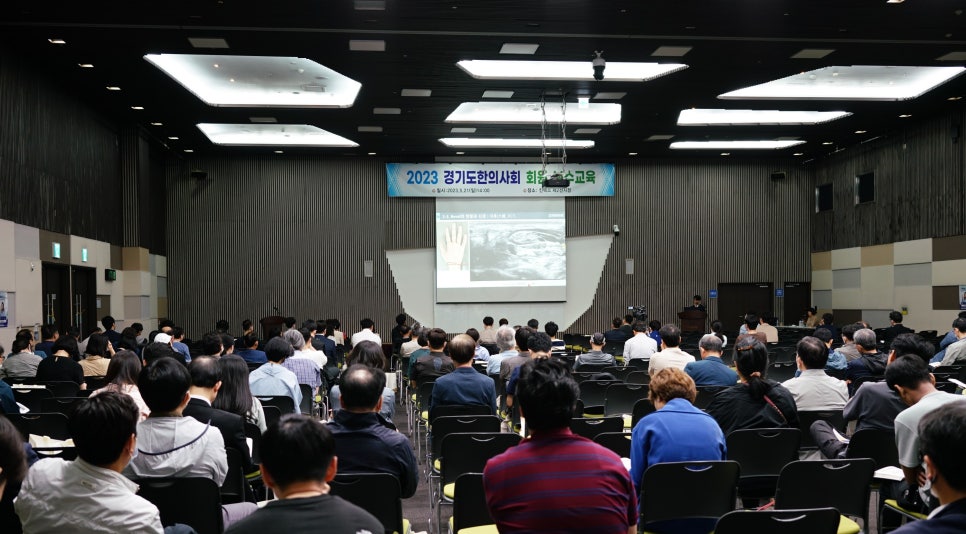 한의사들이 강당에 모여 초음파 사진이 보이는 화면을 보며 교육을 받고 있는 모습