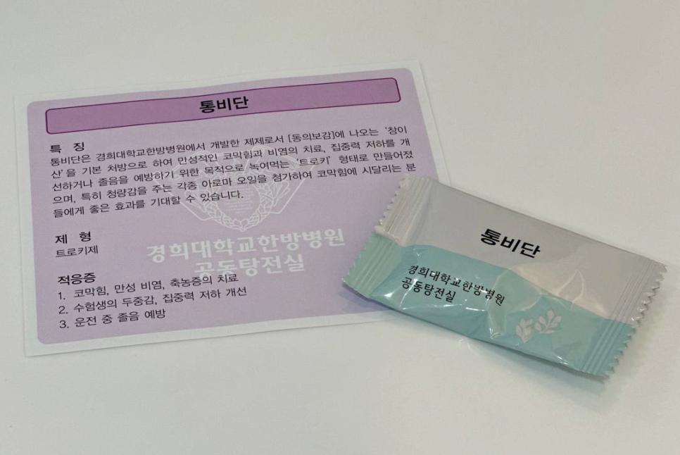 경희대학교한방병원 통비단 정보지와 통비단 제품 포장이 놓여 있다.