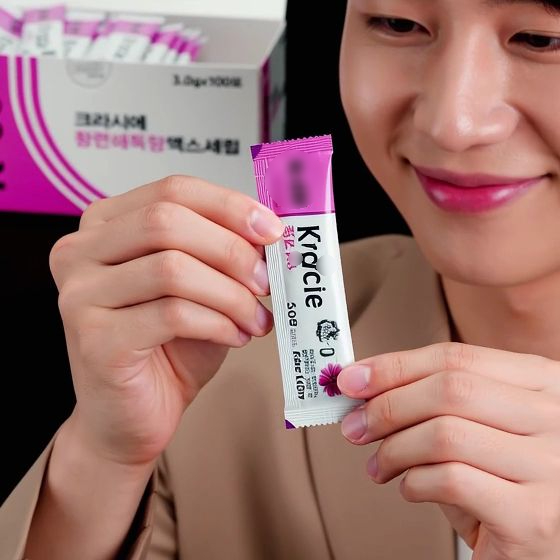 한 남자가 크라시에 황련해독탕 스틱형 포장을 들고 있는 모습.