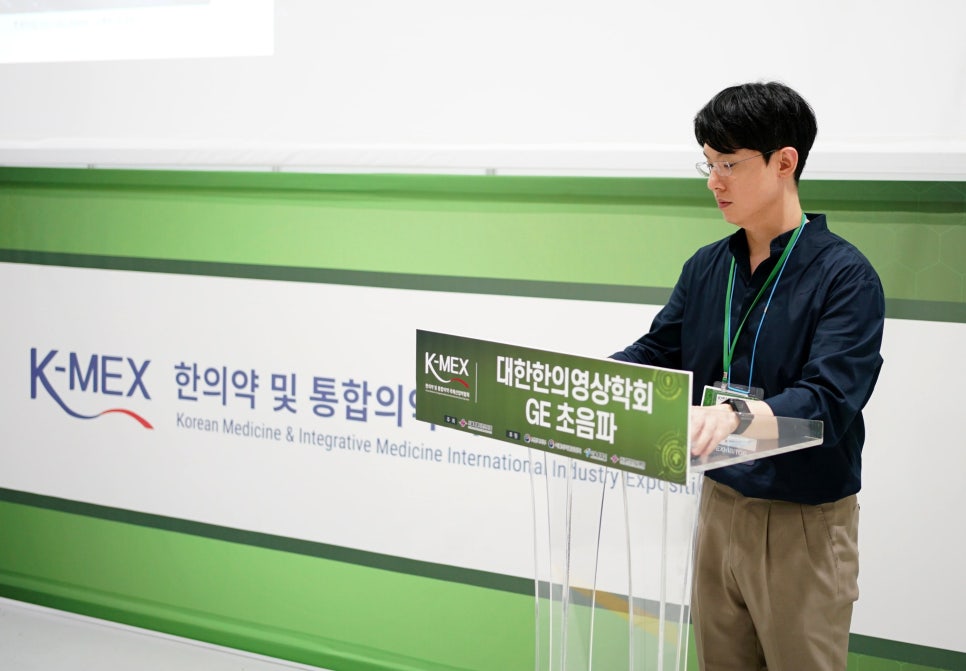 K-MEX 한의약 및 통합의학 박람회에서 한 남성이 연단에서 대한한의영상의학회 GE 초음파 관련 발표를 하고 있다.