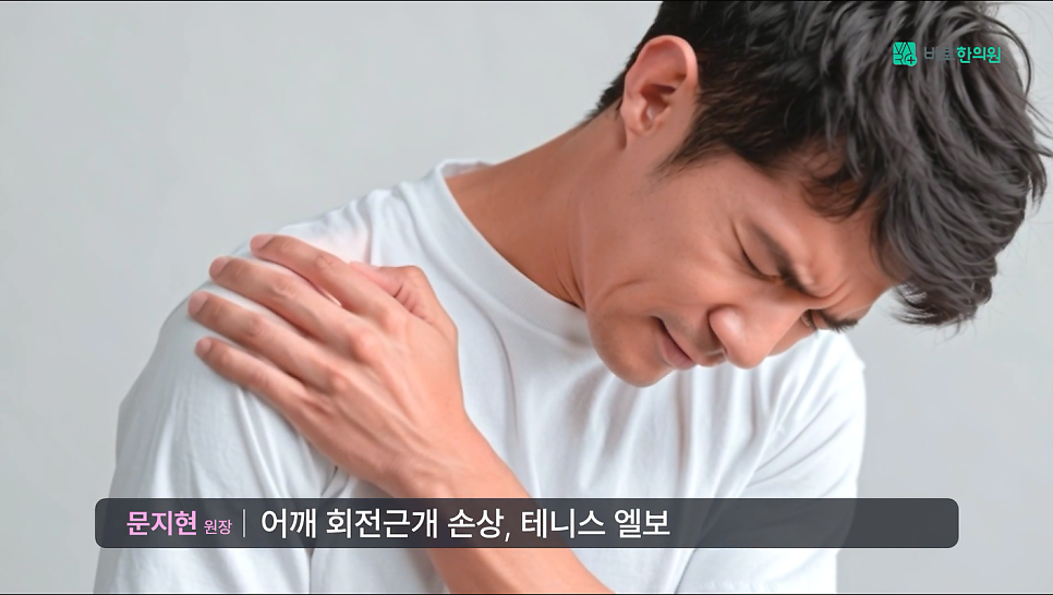흰색 티셔츠를 입은 남성이 아픈 표정으로 어깨를 잡고 있는 모습