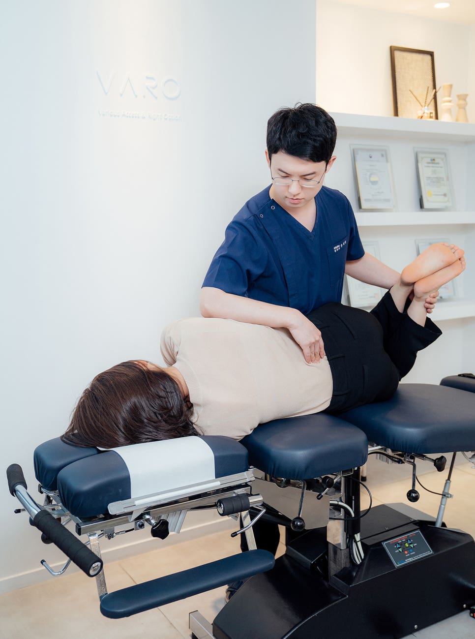 치료사가 치료대 위에 엎드린 환자의 허리에 수기 요법을 시행하는 모습 — 서울 바로한의원 초음파 약침·도침