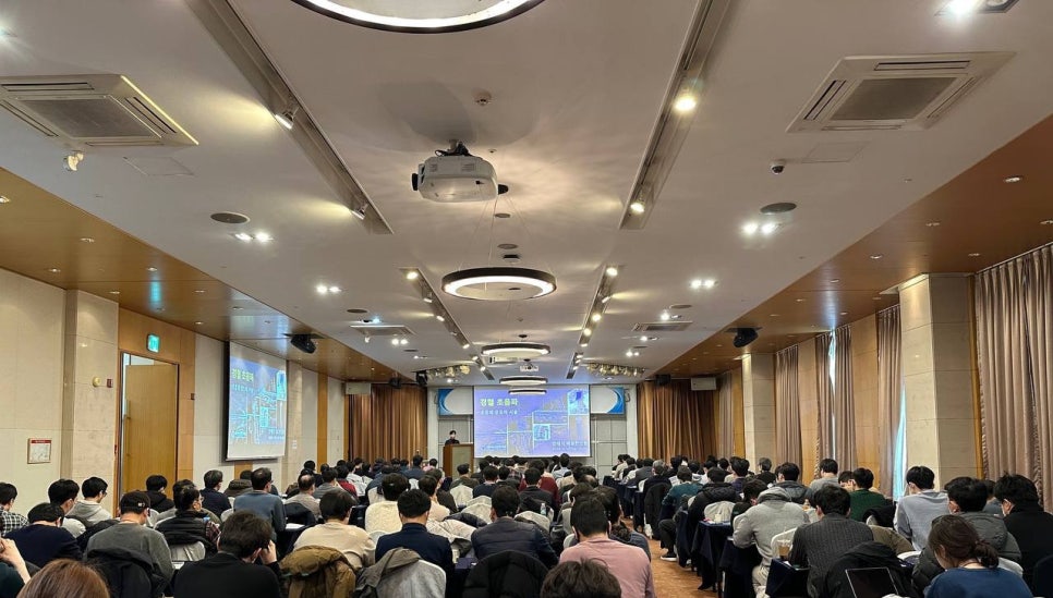 강당에 앉은 많은 사람들이 정형 초음파 관련 강연을 듣고 있는 모습