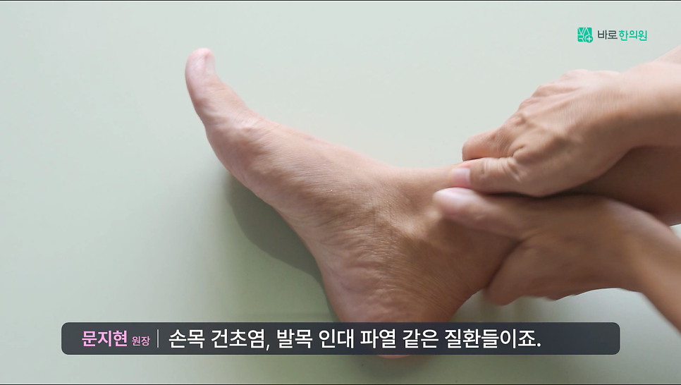 한 사람이 다른 사람의 발목을 손으로 만져보고 있다.