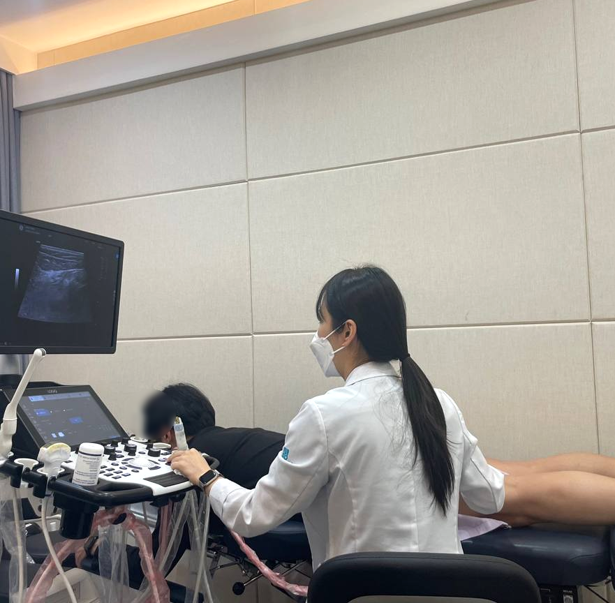 의료진이 초음파 기기를 사용하여 환자의 무릎 뒤쪽 부위에 도침 시술을 하고 있다.