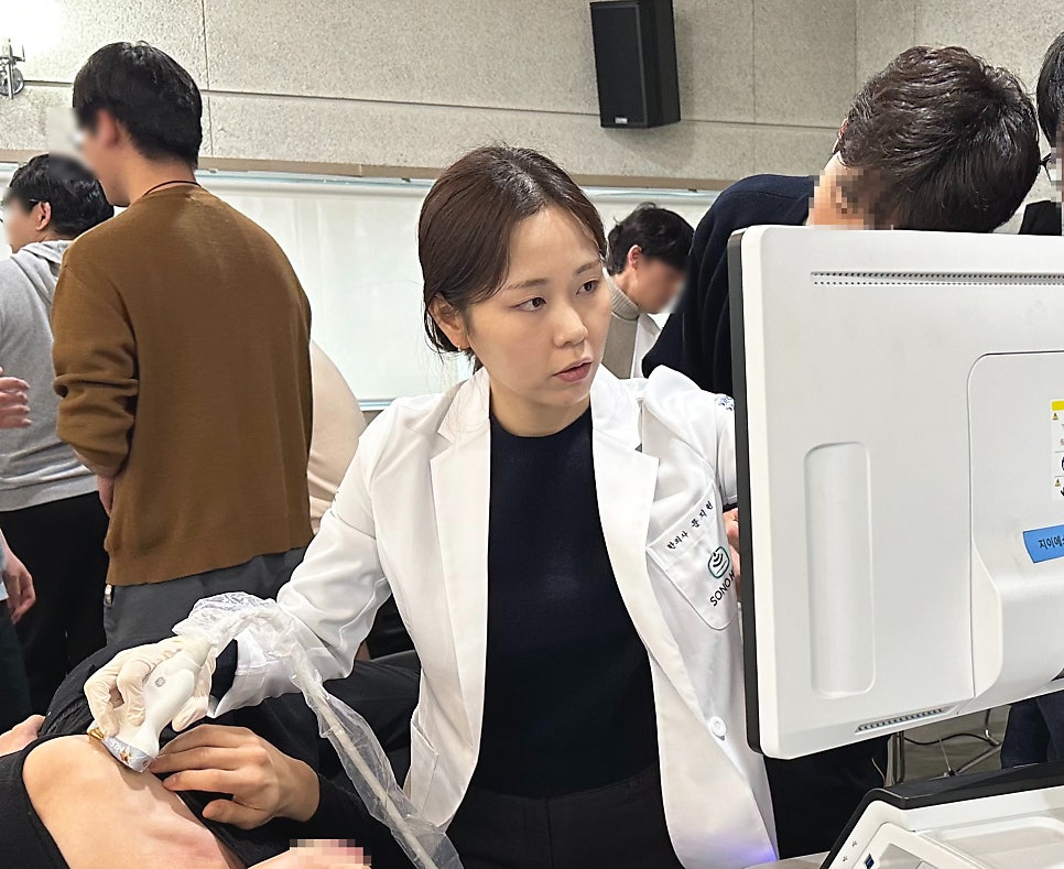 한의사가 환자의 목 부위에 초음파 검사를 하고 모니터를 보고 있는 모습
