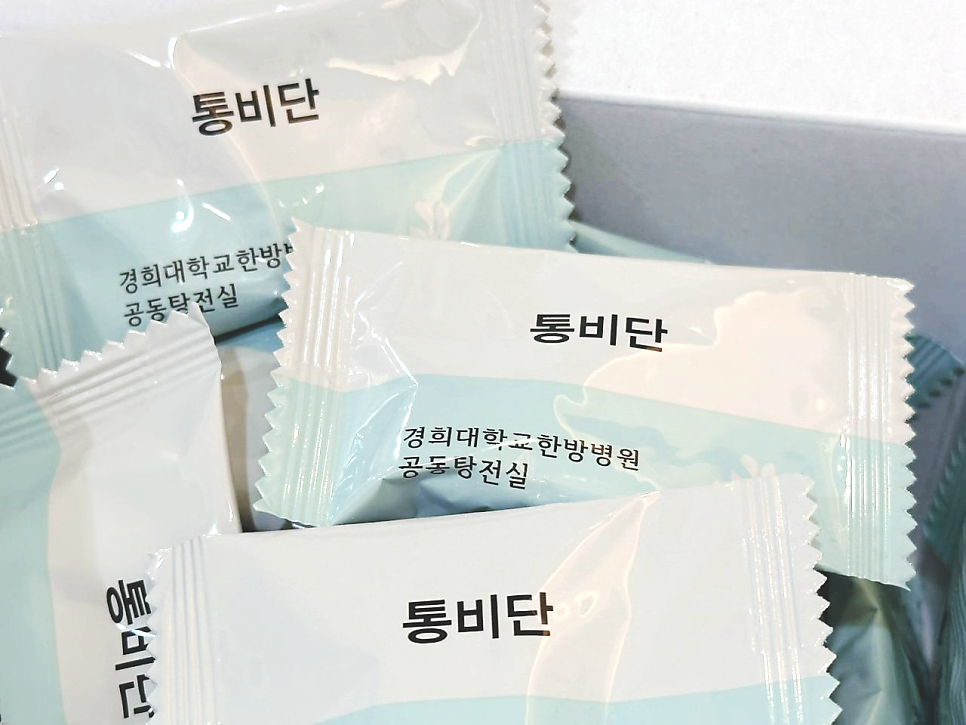 통비단이라고 적힌 흰색과 하늘색 개별 포장 한약 파우치 여러 개가 쌓여 있는 모습.