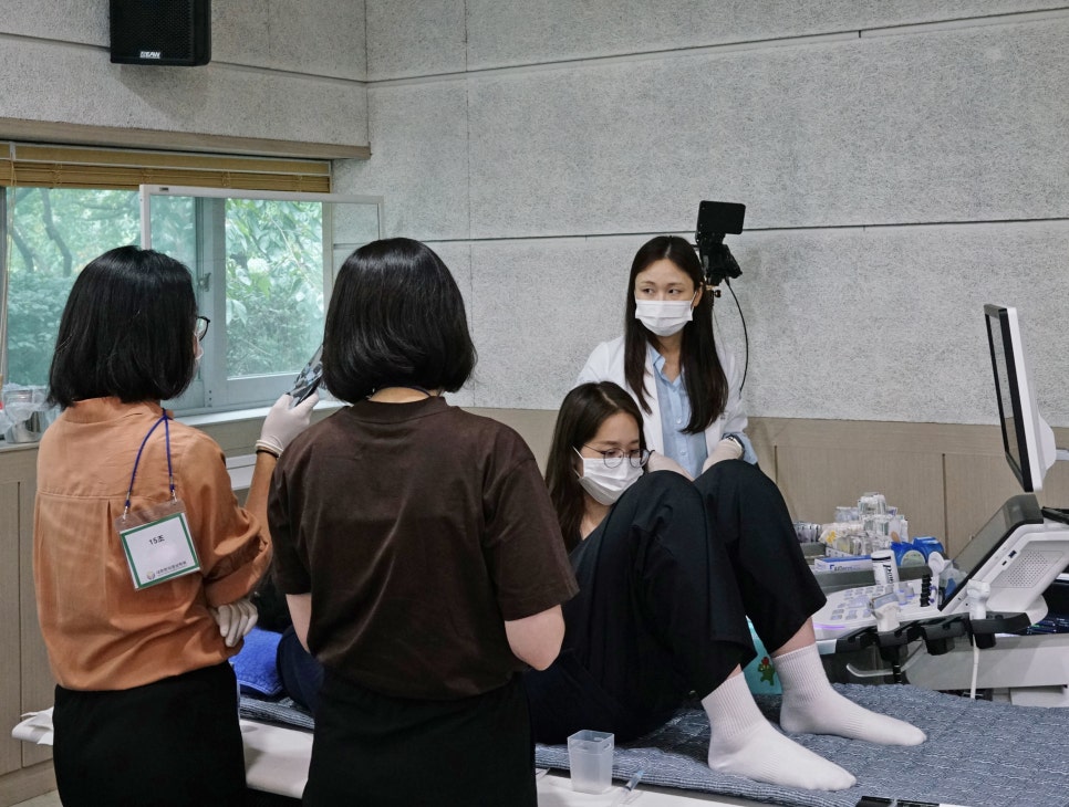 초음파 기기를 이용해 실습하는 여성들과 이를 지켜보는 모습