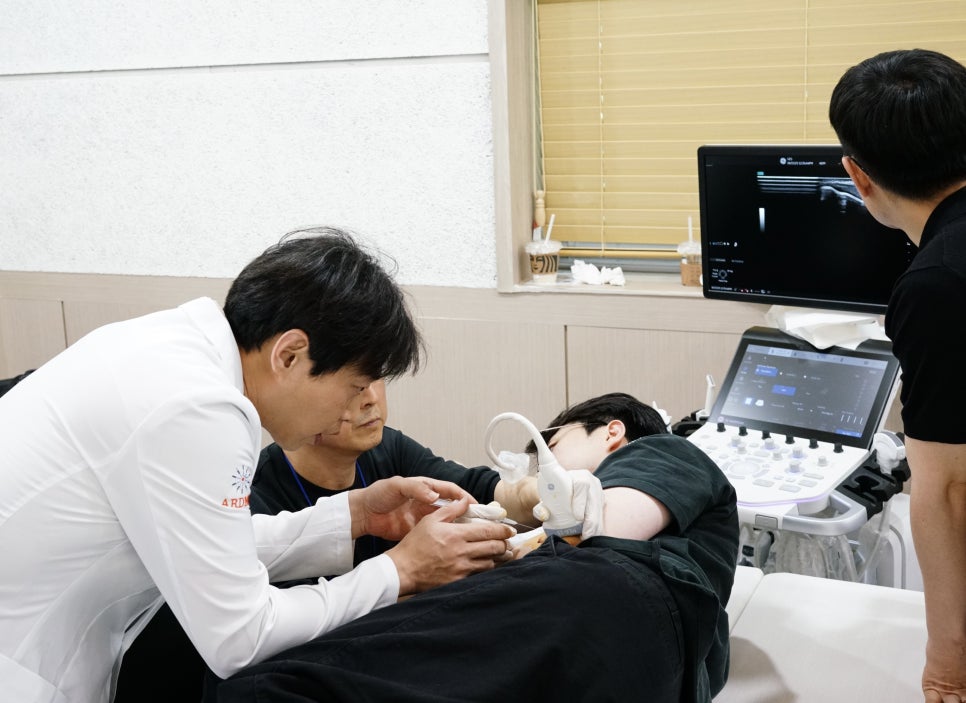 한의사가 환자의 팔에 초음파 기기를 대고 약침 시술을 하는 모습