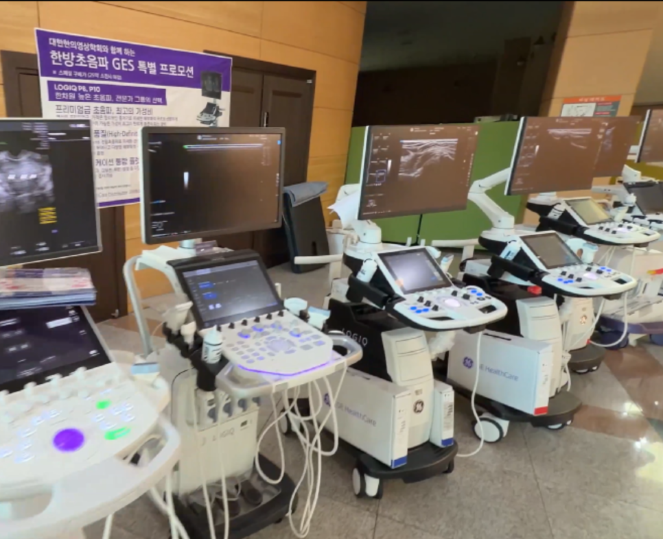 여러 대의 흰색 초음파 기기들이 전시되어 있고, 일부 모니터에는 초음파 영상이 보인다.
